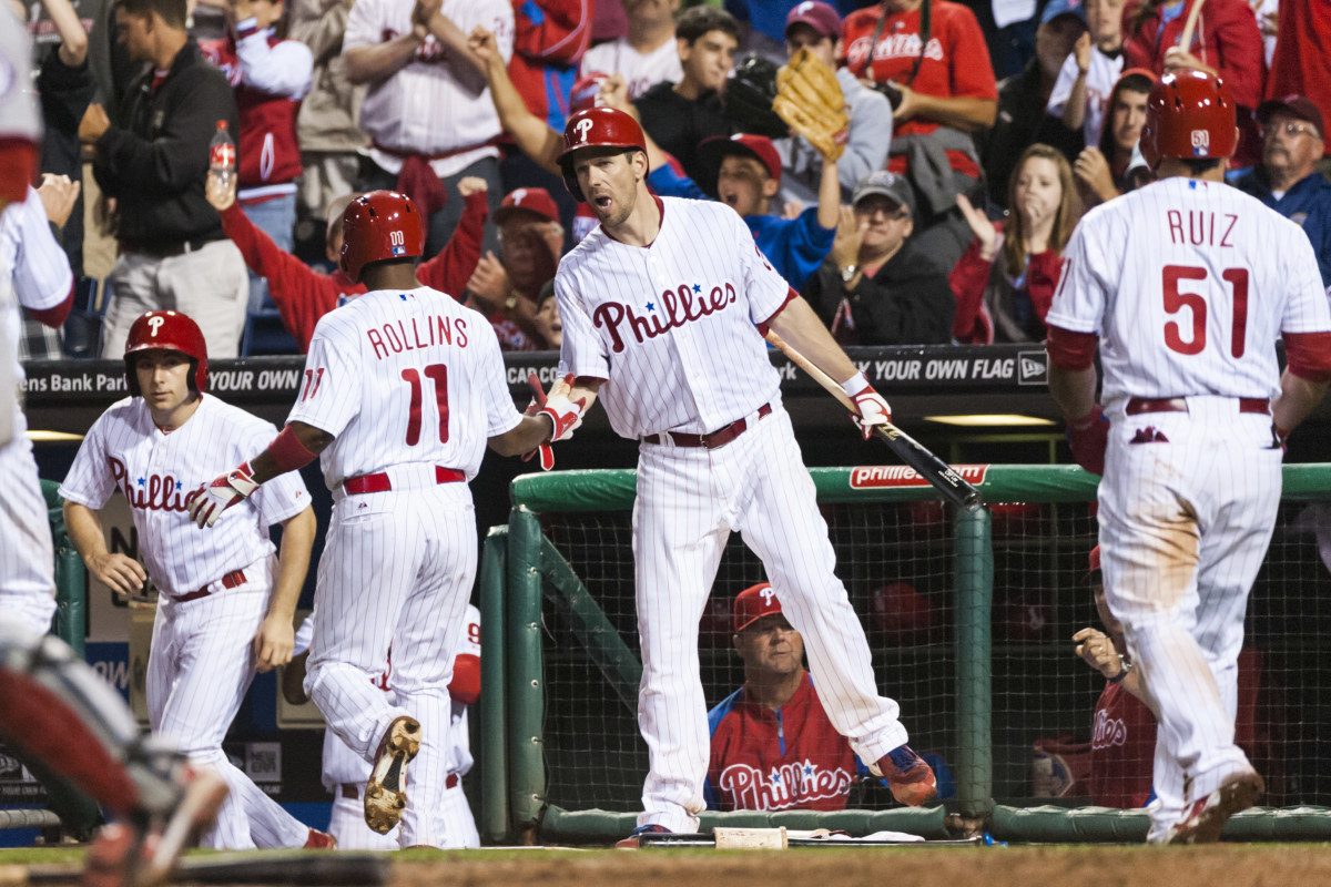 Starting pitcher Cliff Lee congratulates shortstop Jimmy Rollins as he returns to the dugout.